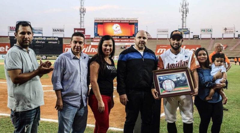 En la tarde de este viernes 05, la Fundación Beto Perdomo otorgó una placa de reconocimiento al profesional Alí Castillo por considerarse el "Bateador más destacado de las Águilas del Zulia" en la temporada regular 2017-2018. David Alastre, integrante de la organización y quien estuvo acompañado de familiares del destacado narrador deportivo Humberto "BETO" Perdomo, fue el encargado de la actividad. Estás fueron sus palabras: "En primer lugar, queremos agradecer a la Directiva, a la alta gerencia de las Águilas del Zulia, particularmente a Luís Rodolfo Machado y a César Collins que comprendieron desde un primer momento el alcance de nuestra propuesta. Beto Perdomo consolidó su nombre sobre la base de los más altos valores morales trazados por el oficio de la comunicación social. (Lea también: Boston negocia duración del contrato con J.D. Martínez) En ese sentido, sus familiares, amigos y seguidores nos hemos organizado con el propósito de premiar a talentos que no sólo cuentan con destrezas y habilidades físicas sino que también elevan al deporte nacional a partir de una adecuada conducta fraterna, solidaria y ejemplar. Hoy esos valores, sentimos que se encuentran recogidos en este joven marabino."